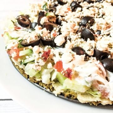 Baked Falafel Pie - A quick and easy meal with layers of falafel, hummus, tomatoes, cucumbers, lettuce, kalamata olives, feta, and tzatziki sauce.