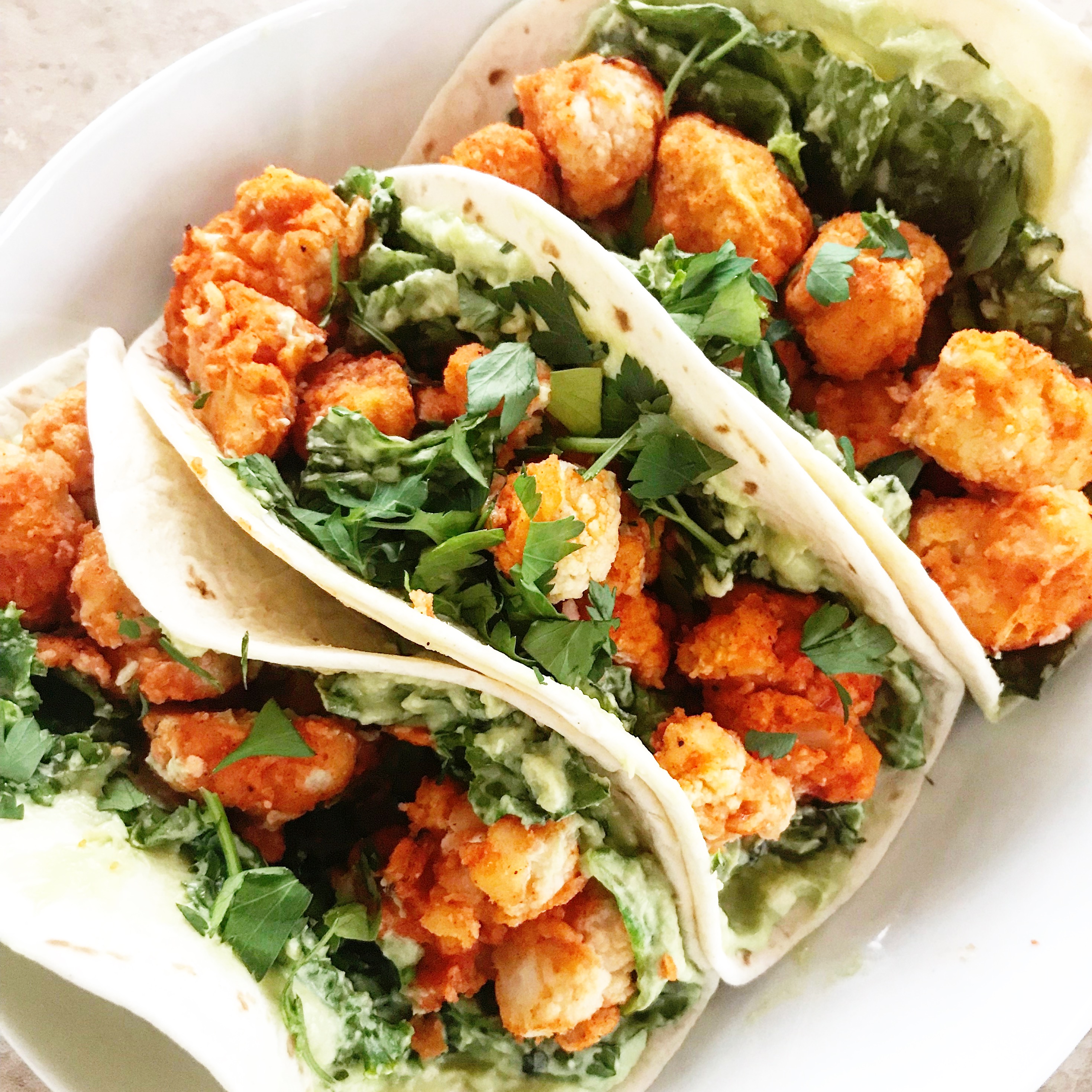 Vegan Twice-Baked Buffalo Cauliflower Tacos  recipe | Spicy Buffalo cauliflower with cool vegan avocado crema. Ready to serve in 30-45 minutes. via @thiswifecooks