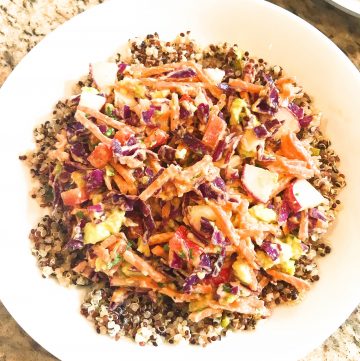 Vegan Red Curry Quinoa Salad - Tri-color quinoa piled with cabbage, carrots, red bell pepper, radishes, scallions, and avocado tossed in red curry sauce.