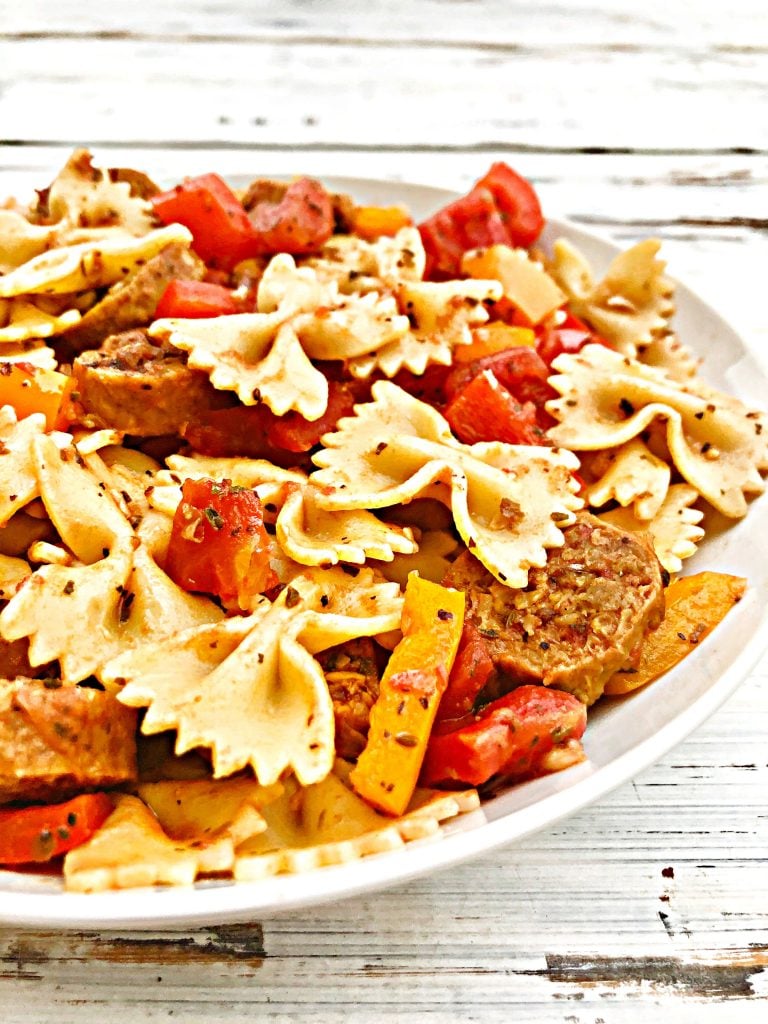 Vegan Sausage and Peppers Pasta - A quick and easy plant-based skillet dinner filled with spicy Italian sausage, colorful bell peppers, and pasta tossed together in a light and earthy tomato sauce. Ready to serve in 30 minutes or less! #sausageandpeppers #easyvegandinners #30minutemeals #vegansausagerecipes #thiswifecooksrecipes #quickandeasydinners #veganquarantinecooking #sausageandpepperspasta