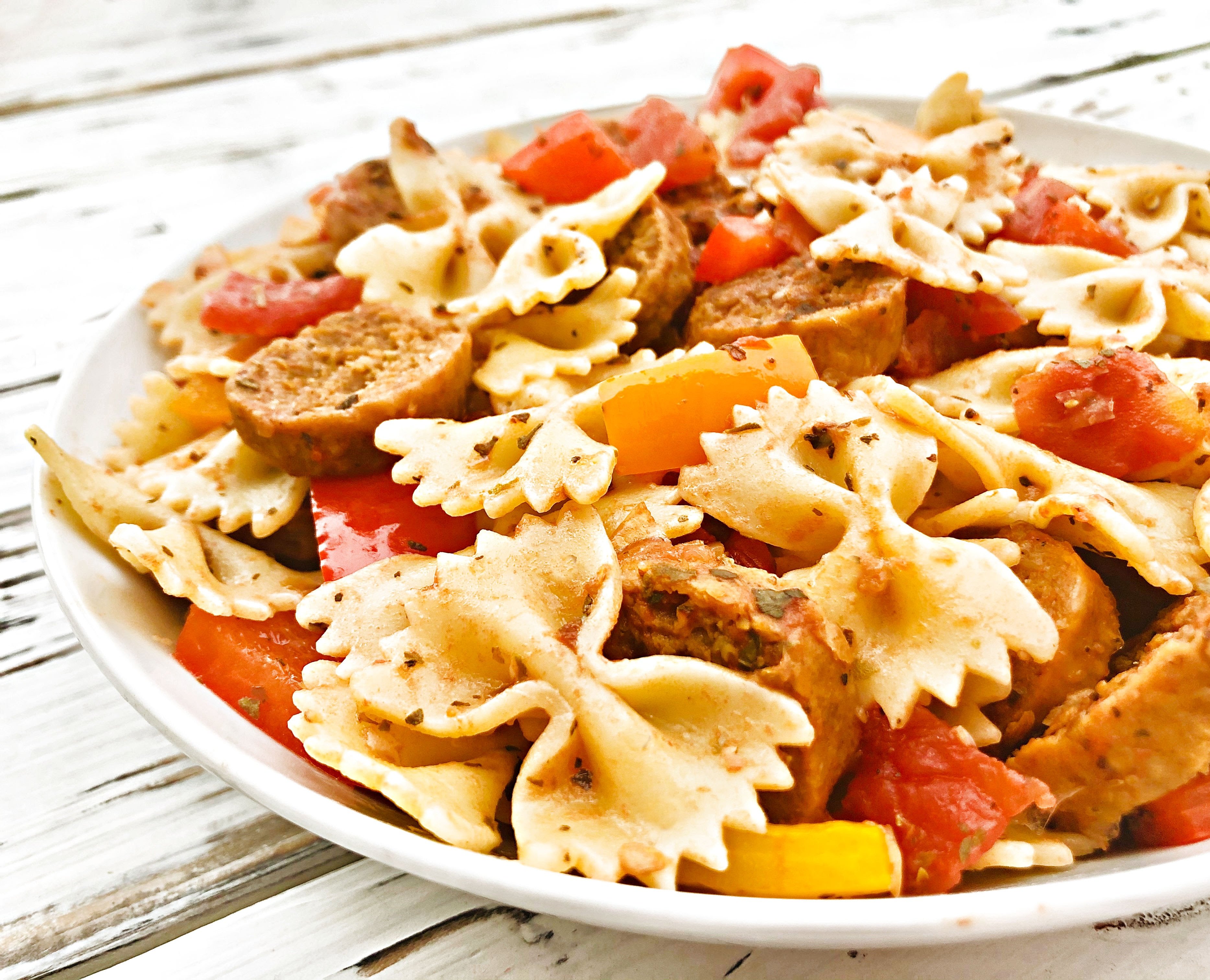 Vegan Sausage and Peppers Pasta - A quick and easy plant-based skillet dinner filled with spicy Italian sausage, colorful bell peppers, and pasta tossed together in a light and earthy tomato sauce. Ready to serve in 30 minutes or less!

#sausageandpeppers #easyvegandinners #30minutemeals #vegansausagerecipes #thiswifecooksrecipes #quickandeasydinners #veganquarantinecooking #sausageandpepperspasta via @thiswifecooks