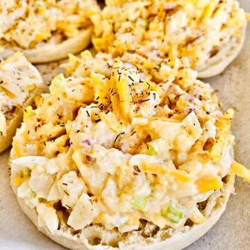 Vegan Crab Melts - Hearts of palm makes a satisfying stand-in for crab in this plant-based and open-faced sandwich perfect for a light dinner, lunch, or brunch. Shredded hearts of palm are combined with vegan mayo and cheddar cheese, celery, red onion, lemon juice, and seasonings then piled onto lightly toasted English muffins. Next, a quick trip under the broiler, just enough to melt the cheese, and these super easy melts are ready to serve. #crabmelts #veganseafoodrecipes #vegancrabmelts #veganbrunchrecipes #thiswifecooksrecipes #easyplantbaseddinner #heartsofpalmrecipes #vegancrabrecipes