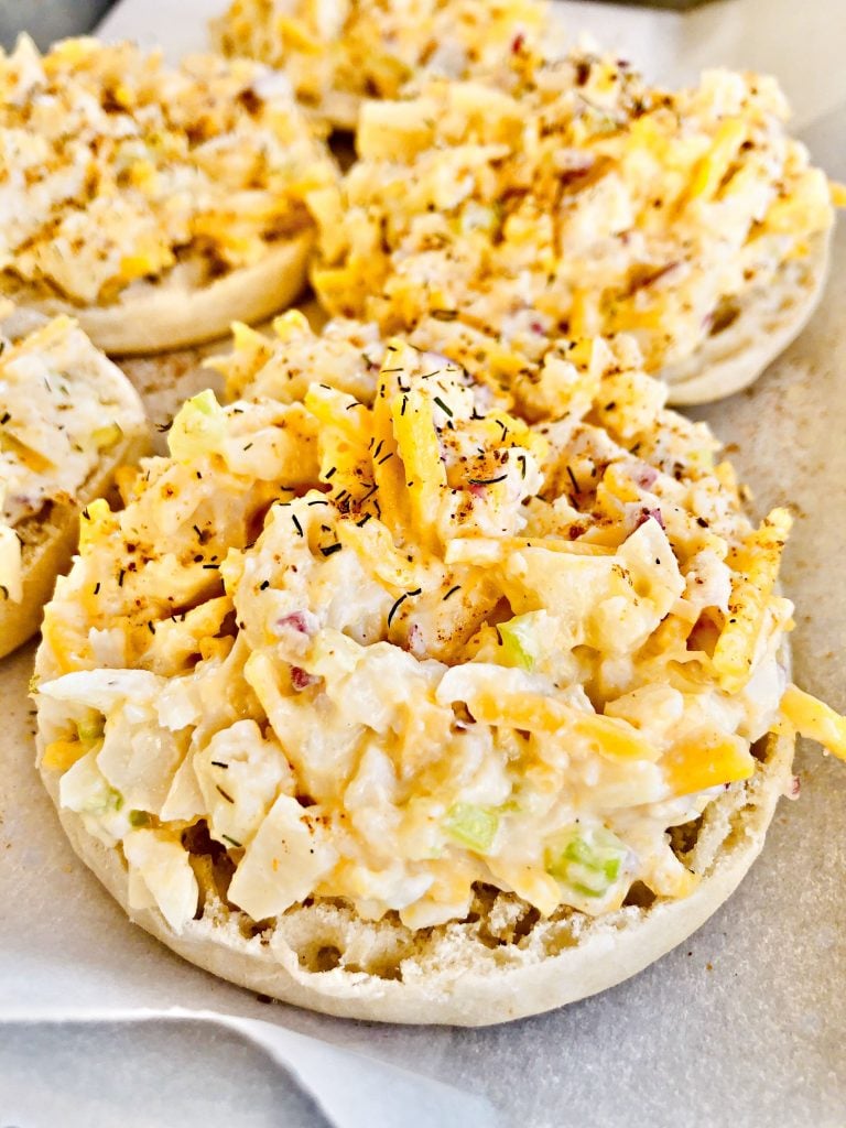 Vegan Crab Melts - Hearts of palm make a satisfying stand-in for crab in this plant-based and open-faced sandwich perfect for a light dinner, lunch, or brunch. Shredded hearts of palm are combined with vegan mayo and cheddar cheese, celery, red onion, lemon juice, and seasonings then piled onto lightly toasted English muffins. Next, a quick trip under the broiler, just enough to melt the cheese, and these super easy melts are ready to serve. #crabmelts #veganseafoodrecipes #vegancrabmelts #veganbrunchrecipes #thiswifecooksrecipes #easyplantbaseddinner #heartsofpalmrecipes #vegancrabrecipes