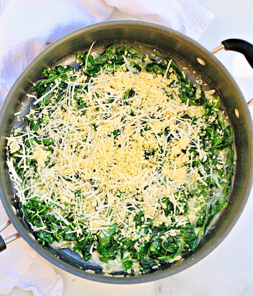 Cheeses added to ingredients in skillet.