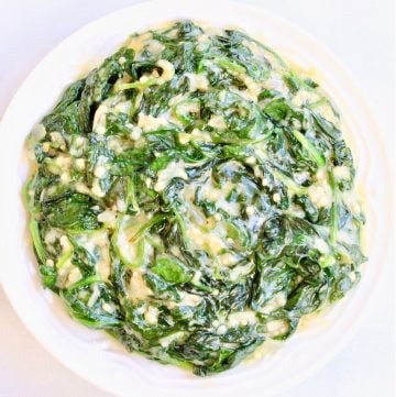 Top down view of vegan creamed spinach in white bowl.
