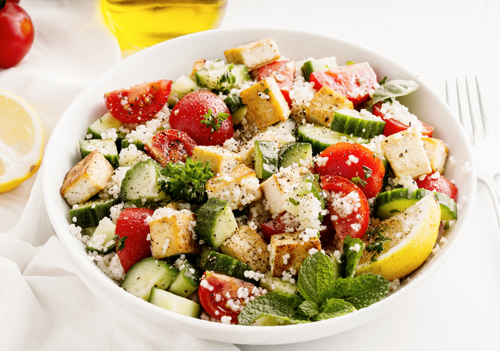 herbed couscous and tofu salad in white bowl in white bowl