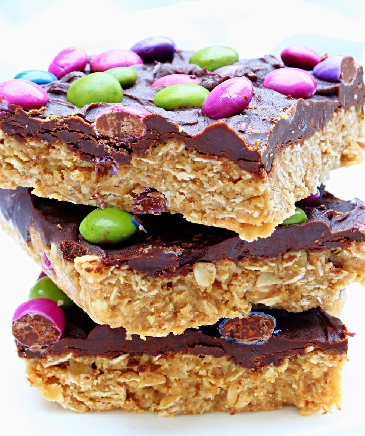 Vegan Monster Cookie Bars ~ Peanut butter and oatmeal cookie dough smothered in chocolate and studded with colorful candies is an easy, no-bake dessert treat that is frightfully delicious!