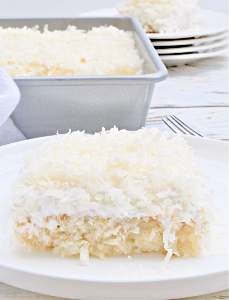 Vegan Coconut Poke Cake ~ Classic white cake infused with tropical coconut flavor then topped with coconut whipped cream and shredded coconut. Perfect for summer entertaining!