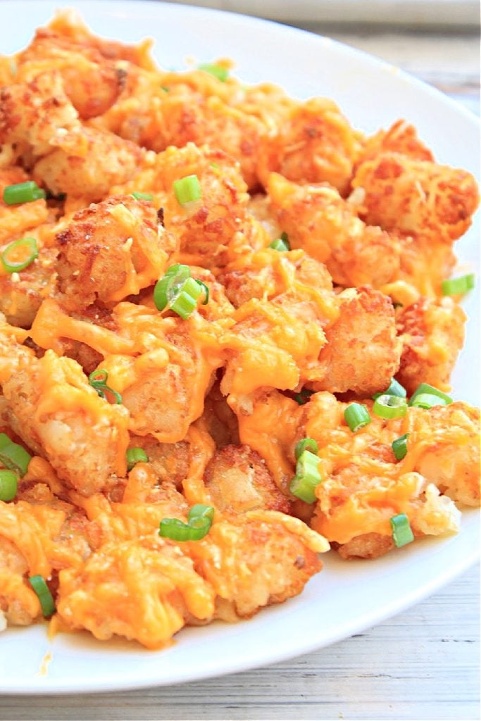 Cheesy Tater Tots ~ Crispy tater tots smothered in shredded cheddar cheese and topped with scallions. The perfect late-night snack indulgence!