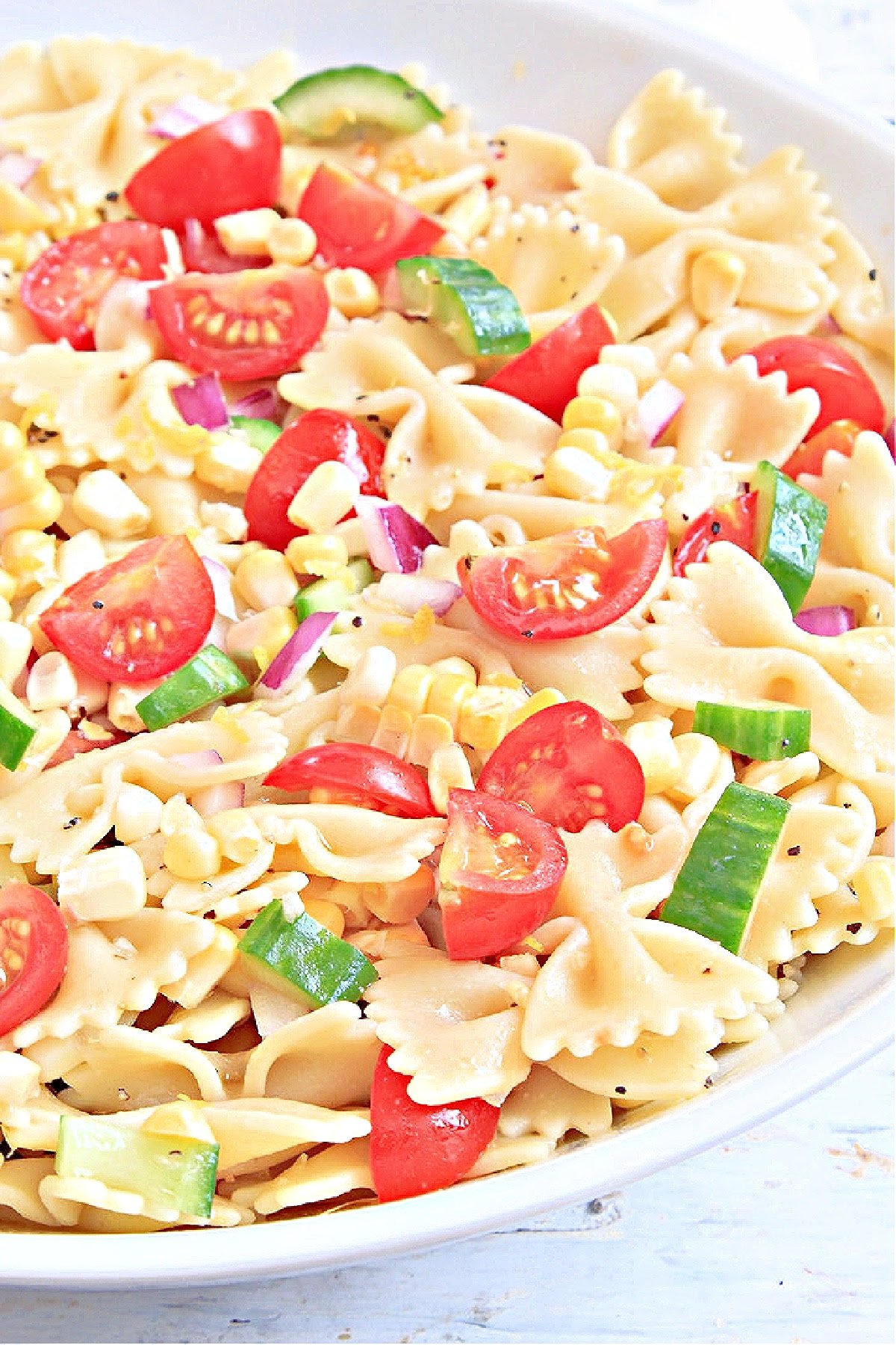 Summer Pasta Salad ~ Fresh from the garden vegetables tossed with farfalle pasta and tangy homemade lemon dressing. Perfect for all your summertime potlucks and cookouts!