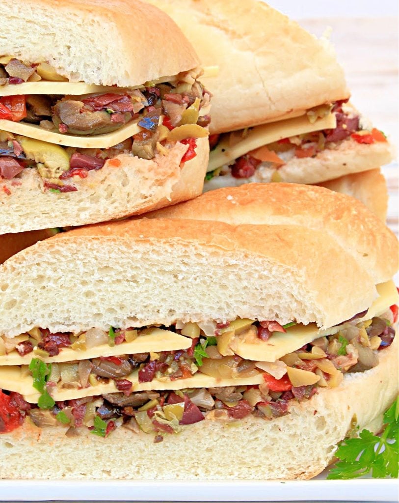 Vegan Muffuletta Subs ~ Italian deli-style olive mix, including three varieties of chopped olives, pickled veggies, roasted red peppers, capers, garlic, and herbs, layered with vegan cheese and pressed between thick slices of sub bread for a flavorful meat-free spin on the New Orleans classic!