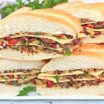 Vegan Muffuletta Subs ~ Italian deli-style olive mix, including three varieties of chopped olives, pickled veggies, roasted red peppers, capers, garlic, and herbs, layered with vegan cheese and pressed between thick slices of sub bread for a flavorful meat-free spin on the New Orleans classic!