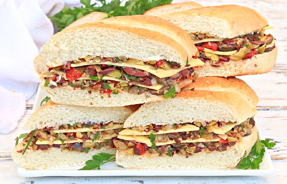 Vegan Muffuletta Subs ~ Italian deli-style olive mix, including three varieties of chopped olives, pickled veggies, roasted red peppers, capers, garlic, and herbs, layered with vegan cheese and pressed between thick slices of sub bread for a flavorful meat-free spin on the New Orleans classic!