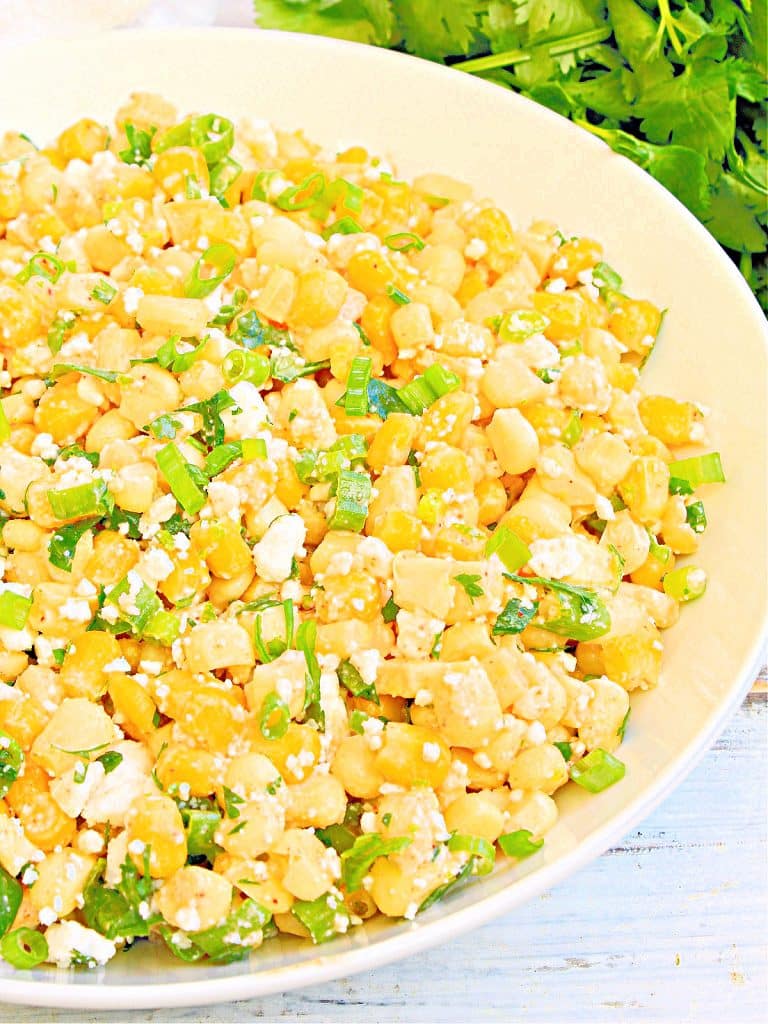Mexican Corn Salad ~ Sweet corn tossed with a creamy lime dressing, cilantro, scallions, jalapeno, and dairy-free cheese. Perfect for potlucks, picnics, or an easy side for dinner at home! 