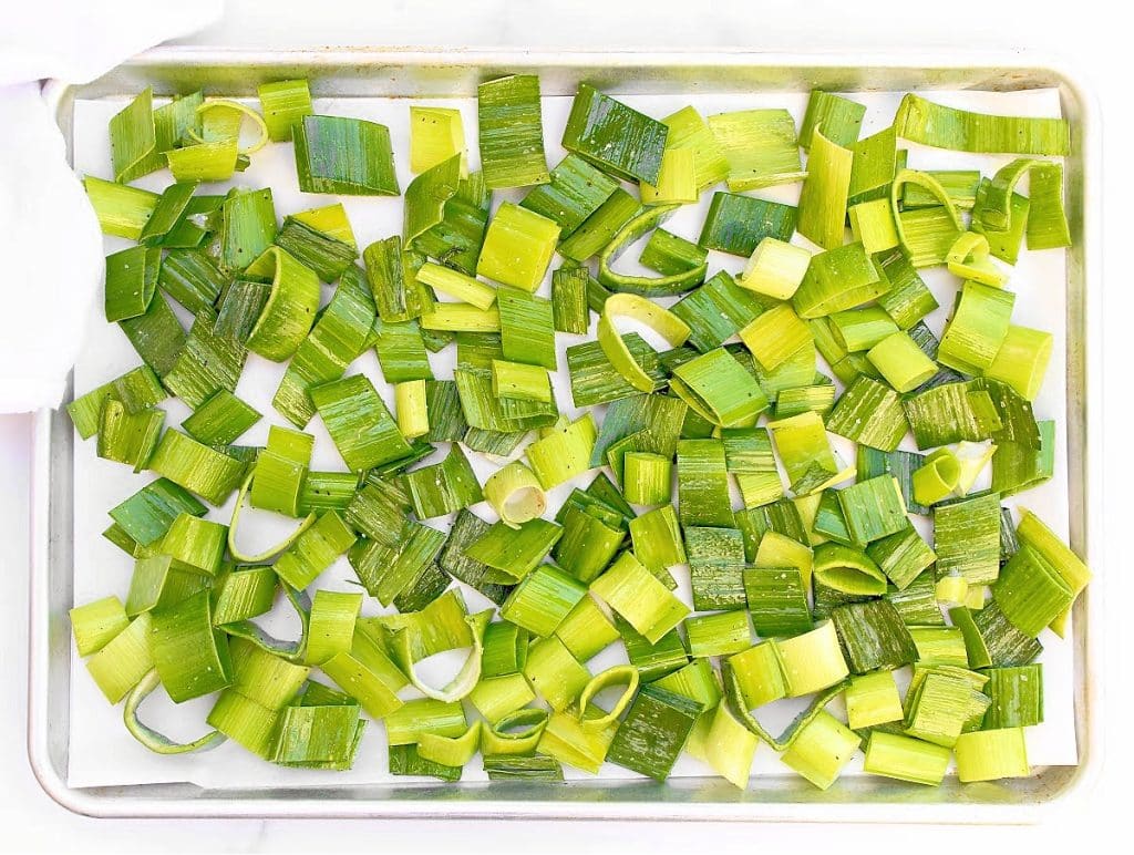 leek greens sliced and arranged on a roasting pan