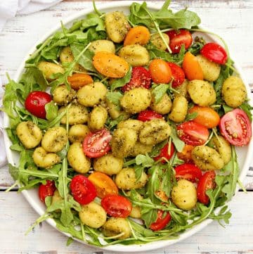 Pesto Gnocchi Salad ~ Roasted gnocchi coated in Homemade Basil Pesto and served over a bed of peppery arugula with bright cherry tomatoes.