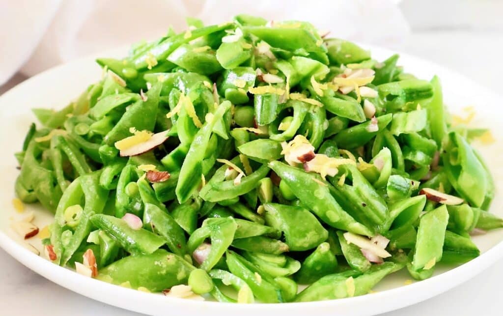 Fresh and flavorful Snap Pea Salad recipe! Crisp sugar snap peas tossed with toasted almonds and a zesty lemon dressing. Perfect for a light lunch or side dish. Vegetarian and vegan-friendly. #SnapPeaSalad #VegetarianRecipes #HealthyEating