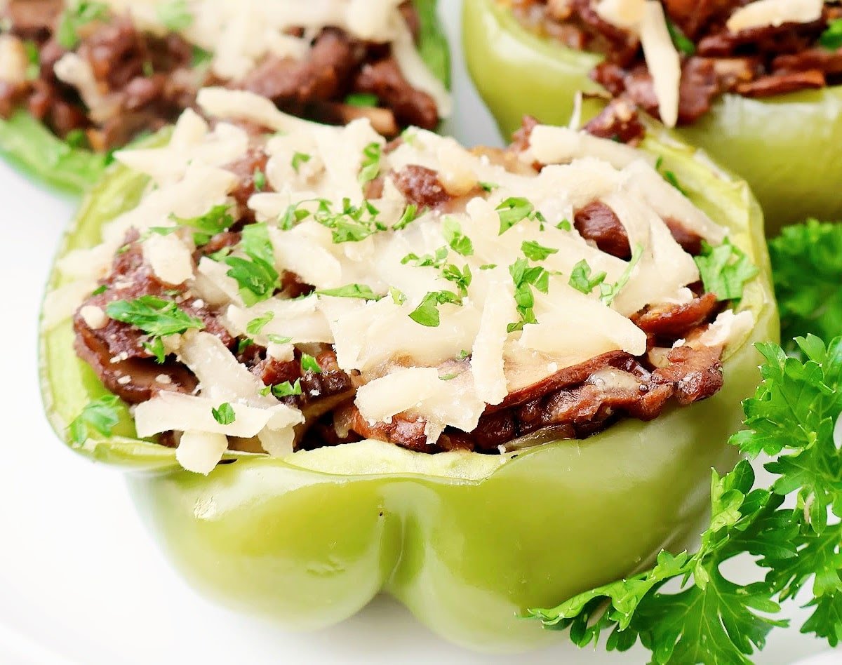 Vegan Cheesesteak Stuffed Peppers ~ Thin sliced vegan steak, sautéed mushrooms and onions, and melted cheese stuffed inside crisp green peppers and roasted to perfection.