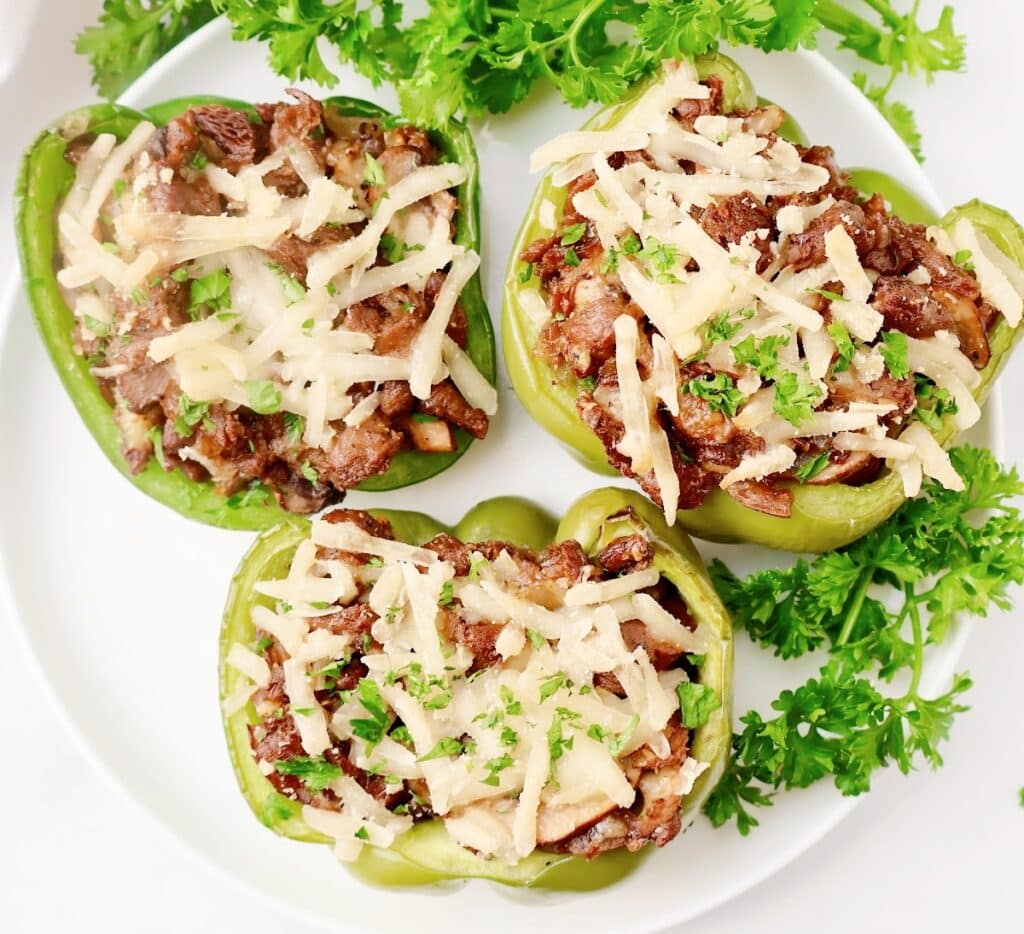 Vegan Cheesesteak Stuffed Peppers ~ Thin sliced vegan steak, sautéed mushrooms and onions, and melted cheese stuffed inside crisp green peppers and roasted to perfection.