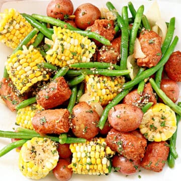 Lowcountry Boil ~ Southern-style feast with red potatoes, plant-based sausage, sweet corn, green beans, and aromatic spices, all drenched in garlic butter.