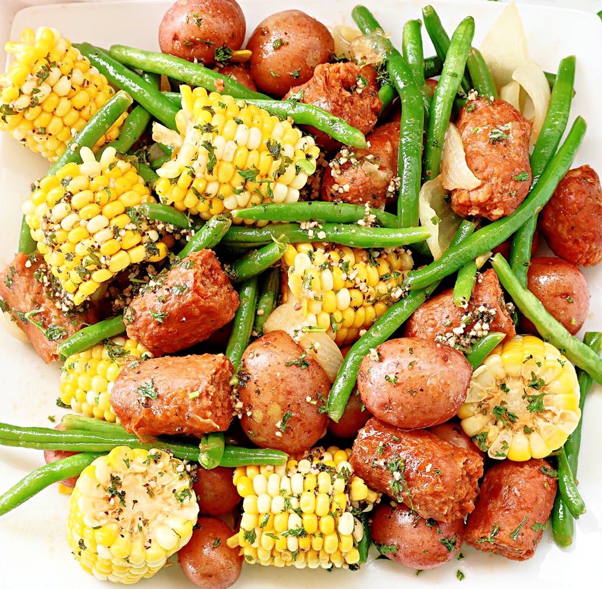 Lowcountry Boil ~ Southern-style feast with red potatoes, plant-based sausage, sweet corn, green beans, and aromatic spices, all drenched in garlic butter.