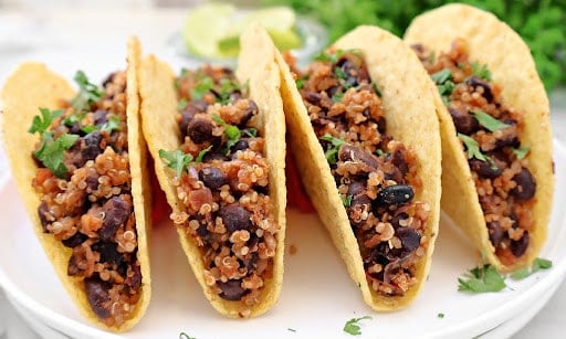 Black Bean Quinoa Tacos ~ Hearty black beans and quinoa cooked with taco spices, lime, and onion, then warmed in crispy shells and ready for your favorite taco toppings. Vegan tacos.