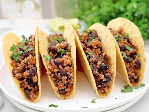 Black Bean Quinoa Tacos ~ Hearty black beans and quinoa cooked with taco spices, lime, and onion, then warmed in crispy shells and ready for your favorite taco toppings. Vegan tacos.