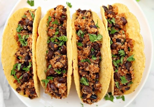 Black Bean Quinoa Tacos ~ Hearty black beans and quinoa cooked with taco spices, lime, and onion, then warmed in crispy shells and ready for your favorite taco toppings. Vegan tacos.