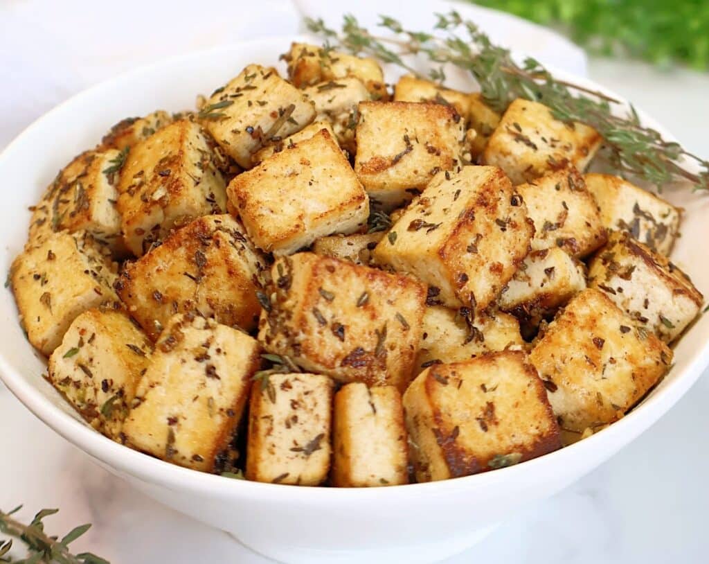 Lemon Herb Tofu ~ Golden-brown tofu marinated in zesty lemon juice, Dijon mustard, garlic, and herbs, then pan-fried to crispy perfection. Easy vegan recipe!