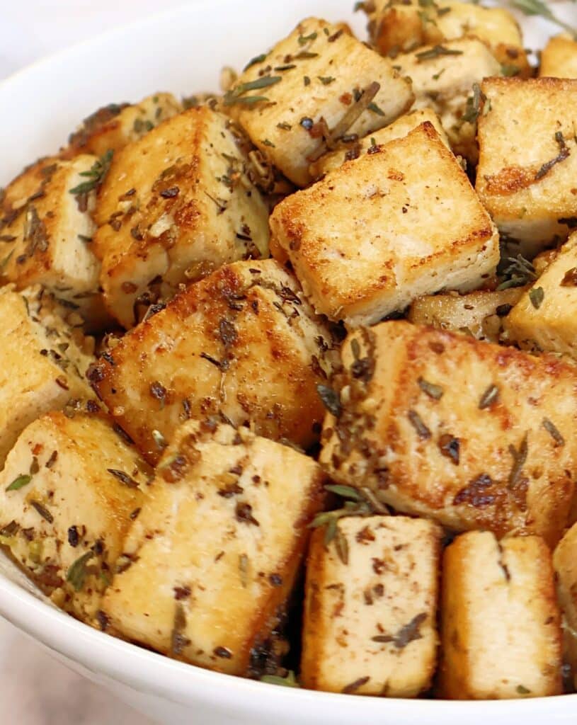 Lemon Herb Tofu ~ Golden-brown tofu marinated in zesty lemon juice, Dijon mustard, garlic, and herbs, then pan-fried to crispy perfection. Easy vegan recipe!