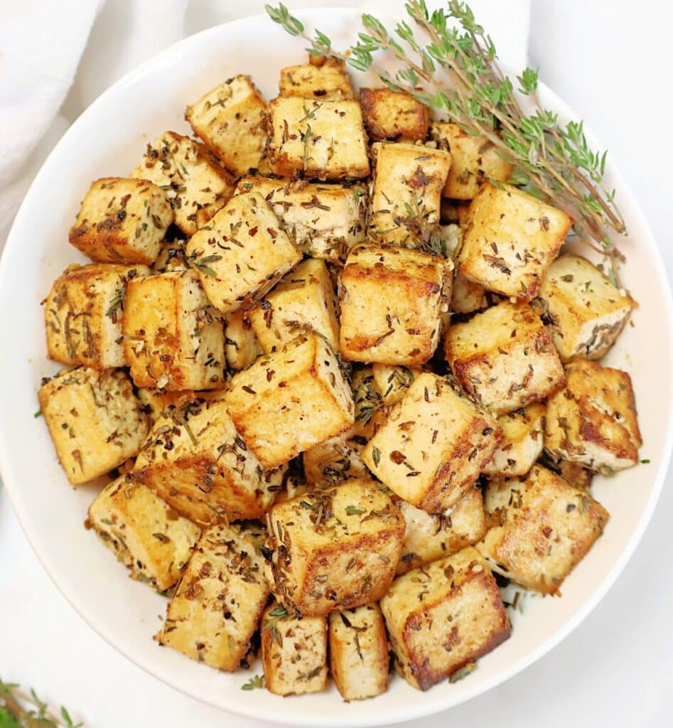 Lemon Herb Tofu ~ Golden-brown tofu marinated in zesty lemon juice, Dijon mustard, garlic, and herbs, then pan-fried to crispy perfection. Easy vegan recipe!