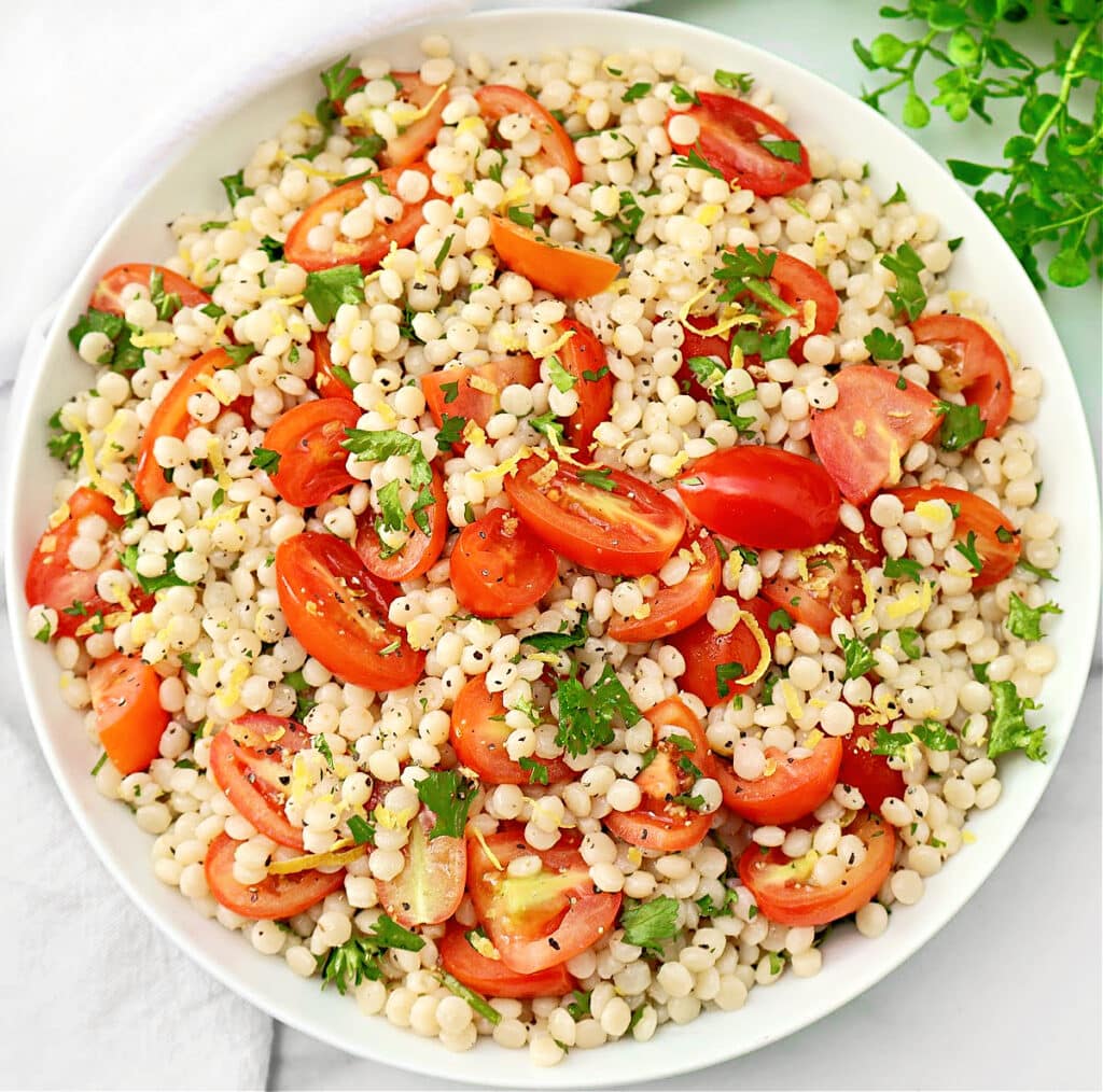 Tomato Couscous ~ Lemony pearl (Israeli) couscous with juicy tomatoes and fresh parsley. Ready in 20 minutes! Vegetarian & Vegan recipe.