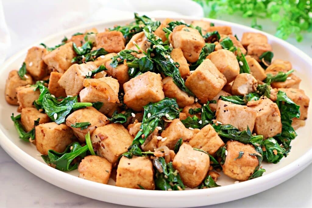 Spinach and Tofu Stir Fry ~ Savory, plant-based stir-fry featuring crisp tofu, sauteed onions, garlic, ginger, and fresh spinach.