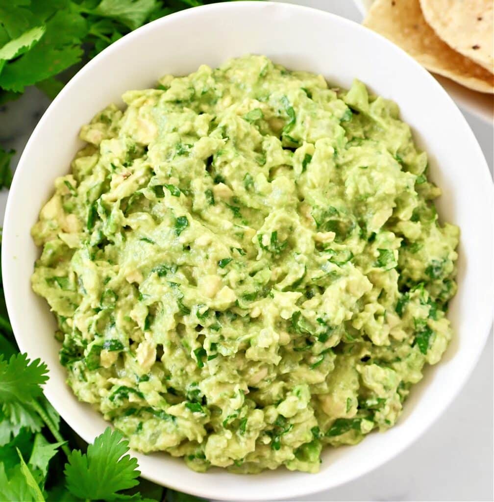 Cilantro Lime Guacamole - Ripe avocados, fresh cilantro, onion, simple seasonings, and lime juice combine to create authentic guacamole in minutes.