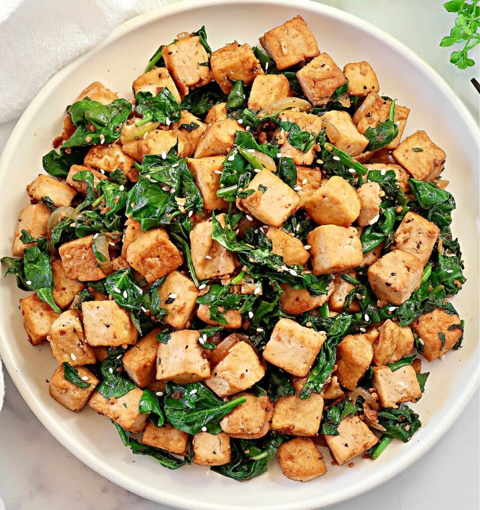 Spinach and Tofu Stir Fry ~ Savory, plant-based stir-fry featuring crisp tofu, sauteed onions, garlic, ginger, and fresh spinach.