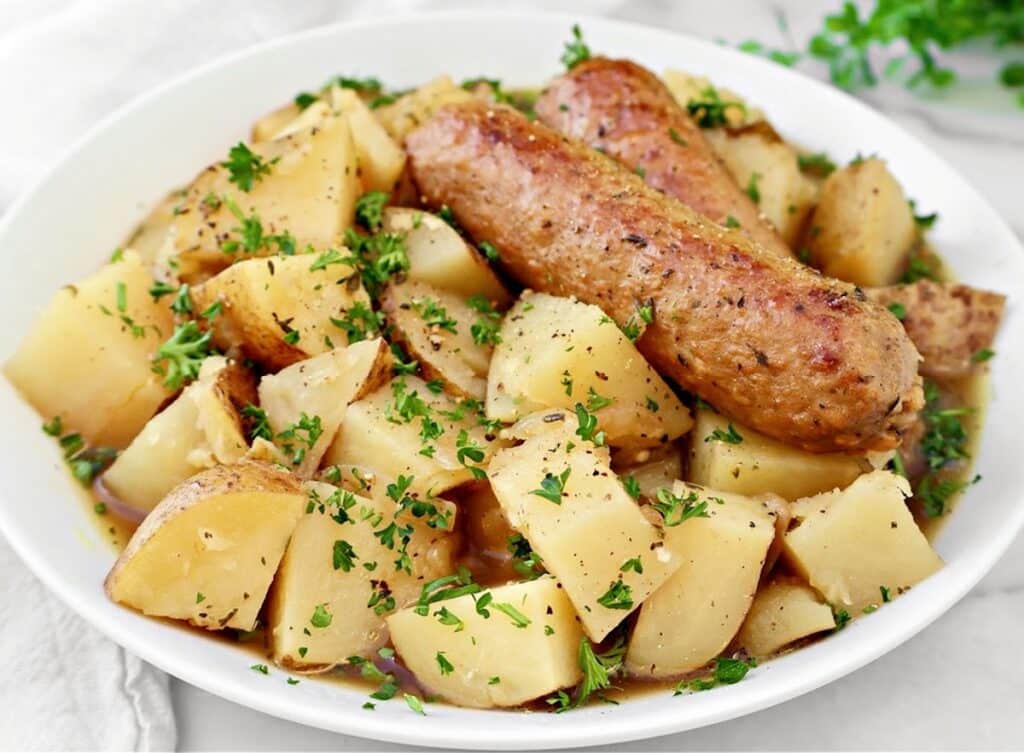 A bowl of Dublin Coddle, a hearty Irish stew made with plant-based sausages, potatoes, and a rich, savory Guinness broth.