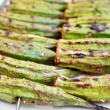 Close-up of Smoky Grilled Okra skewers, showing green okra pods with slight char marks and a coating of spices. Perfect for a Southern okra recipe, the rows of skewers highlight the okra’s texture and rich, smoky flavor.