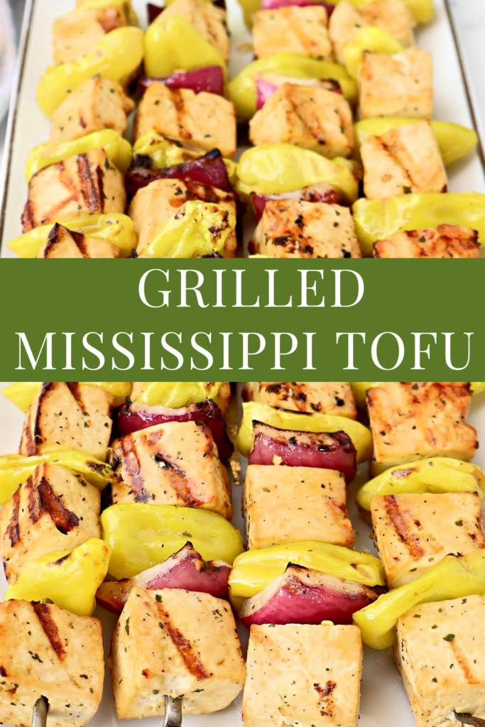 Skewers of grilled tofu, yellow peppers, and red onions are arranged on a tray. The tofu is seared with grill marks. Text overlay reads: “Grilled Mississippi Tofu,” a perfect plant-based twist on classic Mississippi pot roast flavors.