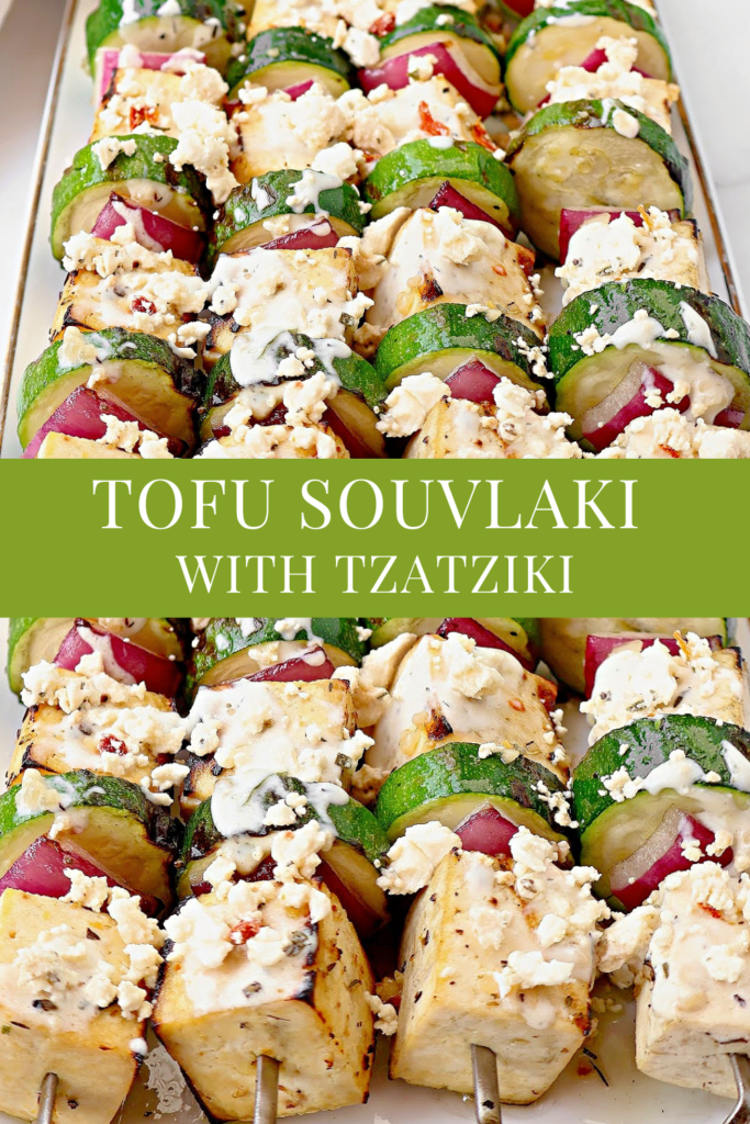 Close-up of tofu souvlaki skewers with zucchini, red onion, and crumbled feta, topped with tzatziki sauce. Text overlay reads: Tofu Souvlaki with Tzatziki—a vibrant Greek tofu recipe.